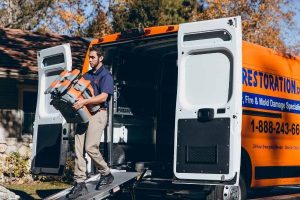 mold removal technician taking equipment out of van