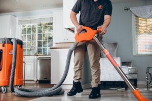 water damage restoration professional extracting water in living room